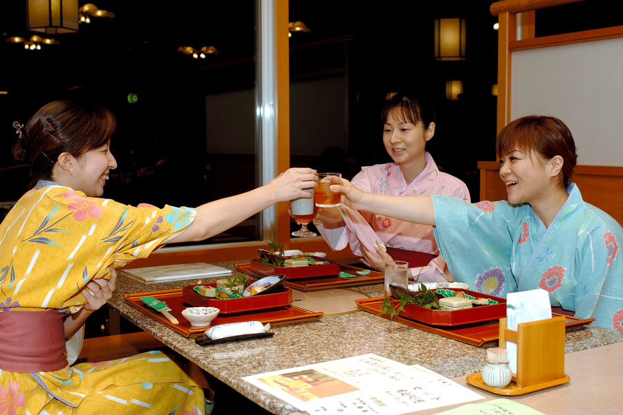 夕食時に乾杯をする女性3人